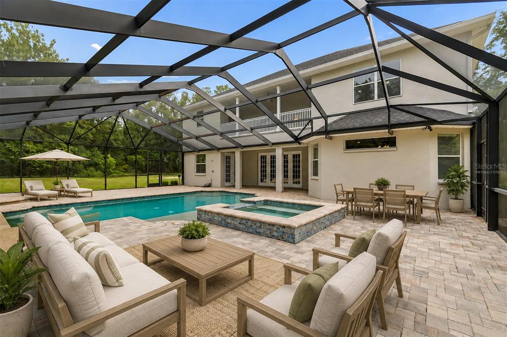 An aerial view of a suburban house with a pool cage surrounded by dense forest — 18326 SUCCESS ROAD, BROOKSVILLE, FL
