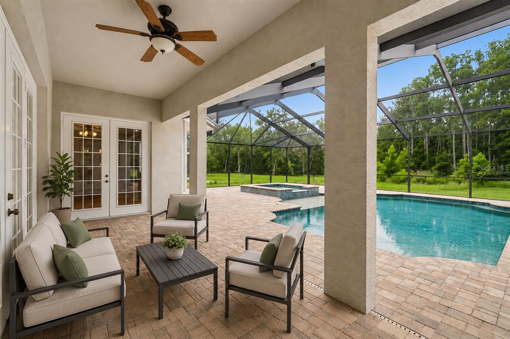A screened-in patio features a swimming pool, a raised spa, and outdoor furniture — 18326 SUCCESS ROAD, BROOKSVILLE, FL
