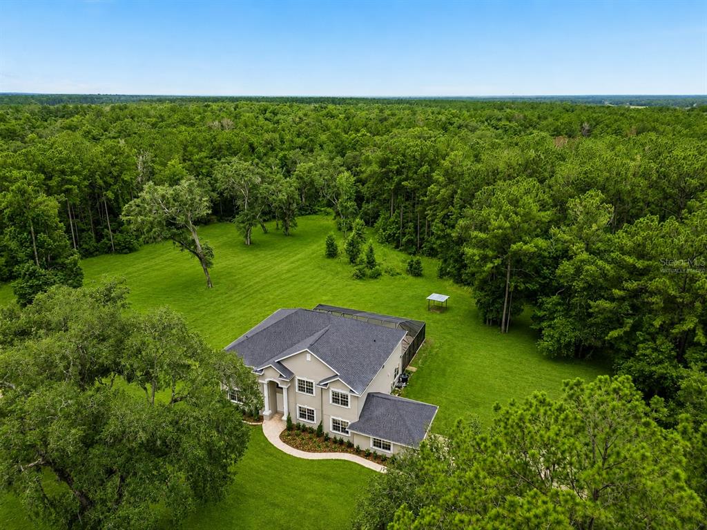 The exterior entrance features double white doors, two large columns, and a brick walkway — 18326 SUCCESS ROAD, BROOKSVILLE, FL