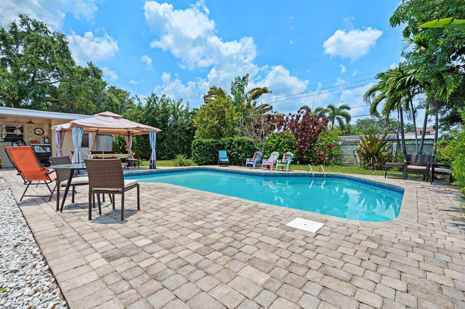 A backyard features a swimming pool, brick paver patio, gazebo, and various outdoor seating areas — 4921 Jackson Street, Hollywood FL 33021, HOLLYWOOD, FL