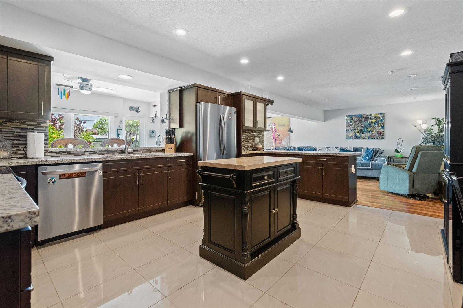 A kitchen with dark wood cabinets, stainless steel appliances, a central island, and tile flooring — 4921 Jackson Street, Hollywood FL 33021, HOLLYWOOD, FL