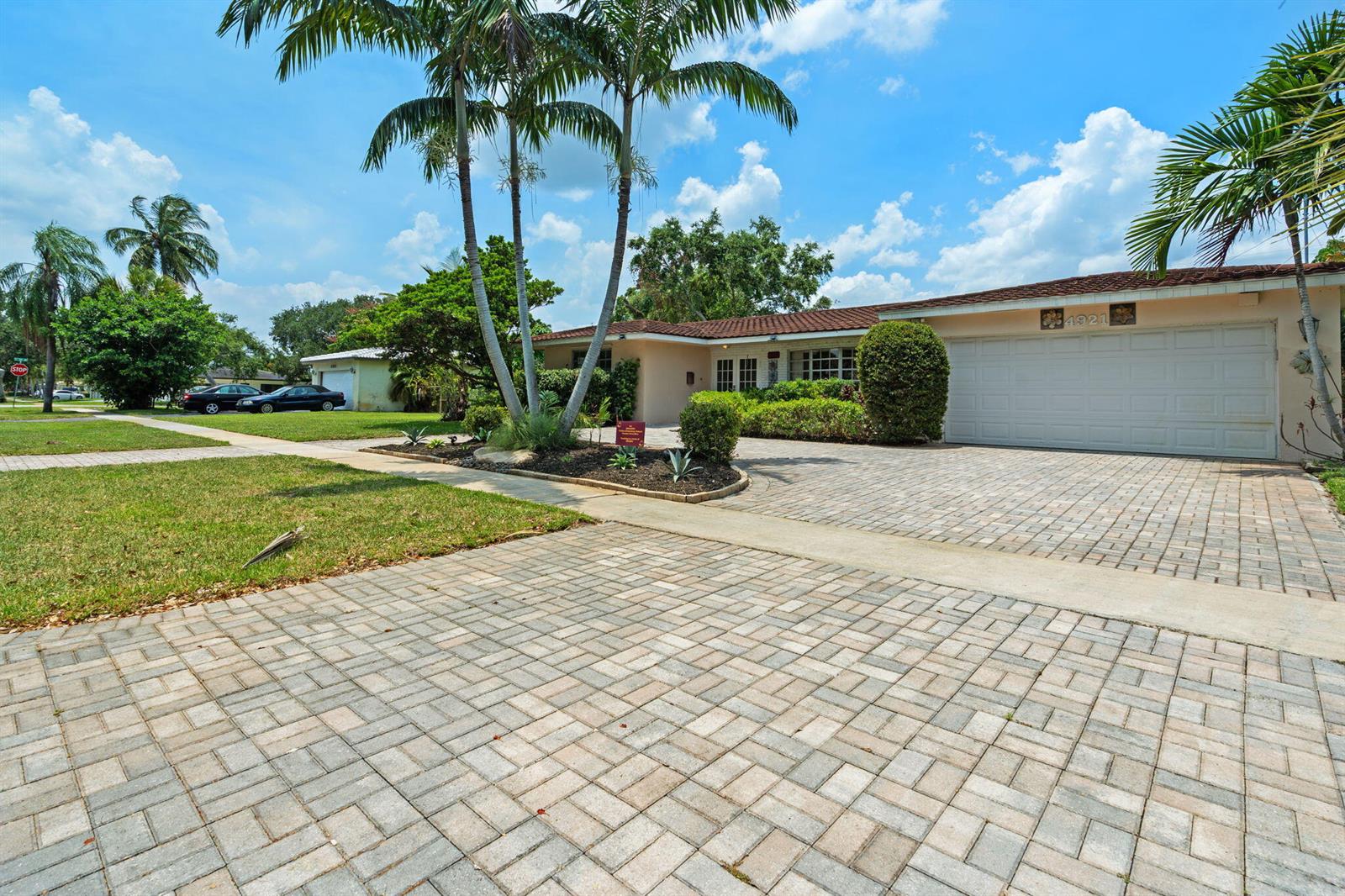 A single-story house with a paved driveway, palm trees, and a two-car garage — 4921 Jackson Street, Hollywood FL 33021, HOLLYWOOD, FL