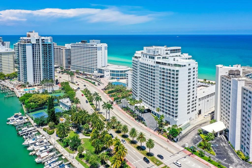 An aerial view shows high-rise buildings, a marina with boats, and a coastal road — 5401 Collins Ave # 920, Miami Beach FL 33140, MIAMI BEACH, FL