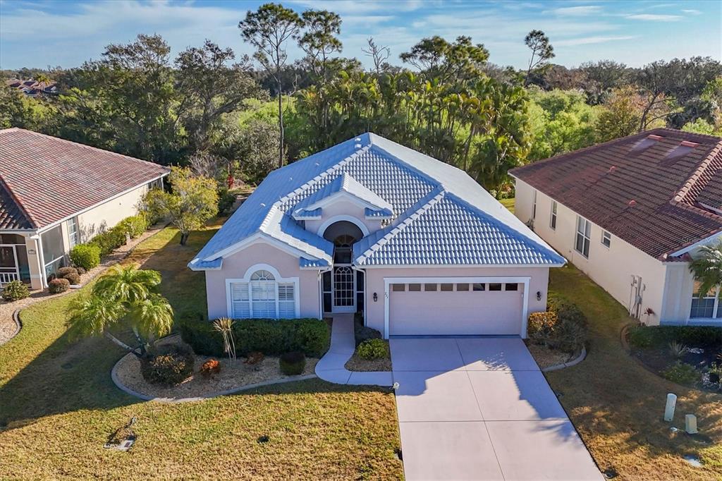 An aerial view of a single-story house with a light-colored exterior and blue tile roof — 711 BACK NINE DRIVE, VENICE, FL