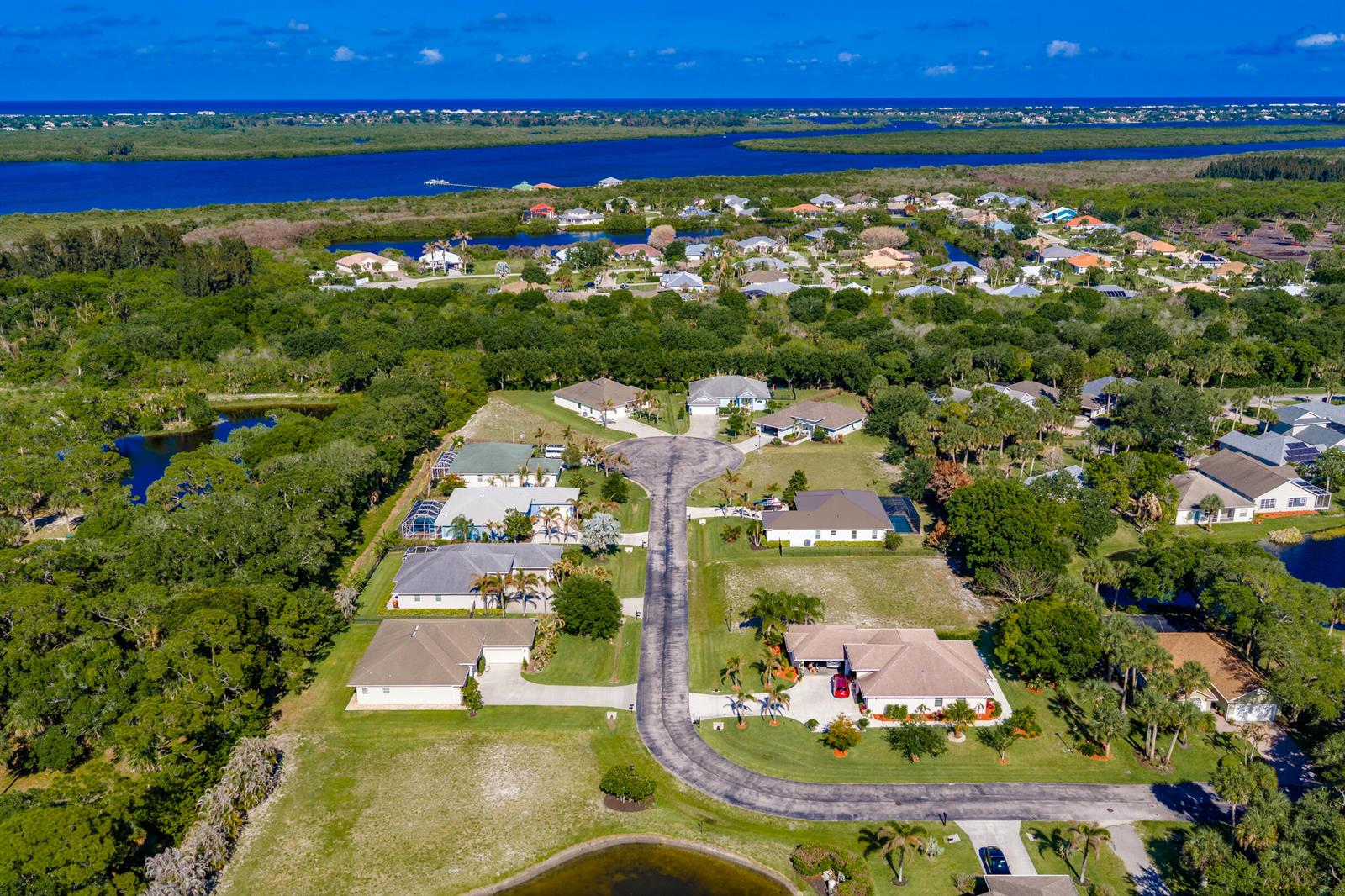 An aerial view of a suburban neighborhood with houses, a cul-de-sac, and surrounding greenery — 7445 36th Court, Vero Beach FL 32967, VERO BEACH, FL