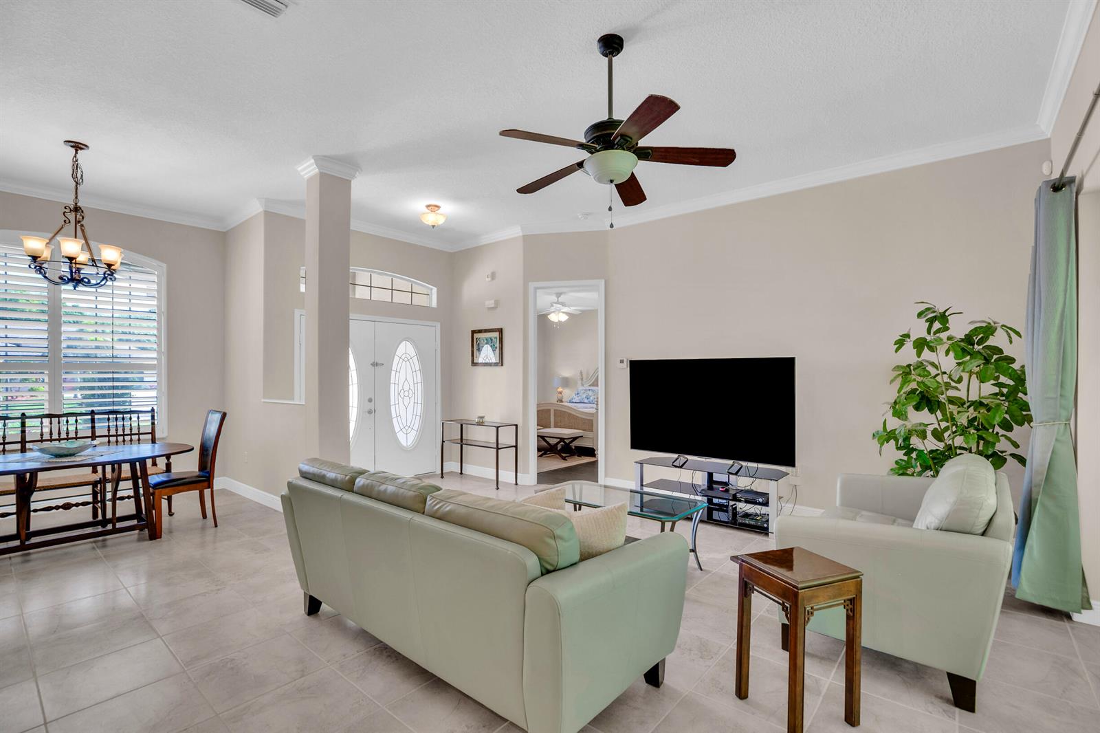 A living room with light tile floors, a ceiling fan, and a dining area nearby — 7445 36th Court, Vero Beach FL 32967, VERO BEACH, FL