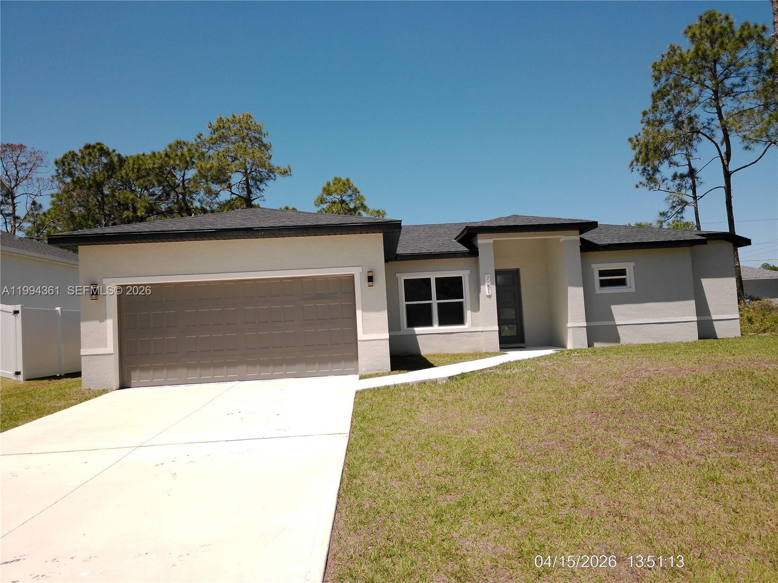 A single-story house with a two-car garage and a concrete driveway under a clear sky — 791 Reading ST SW, Palm Bay FL 32909, PALM BAY, FL