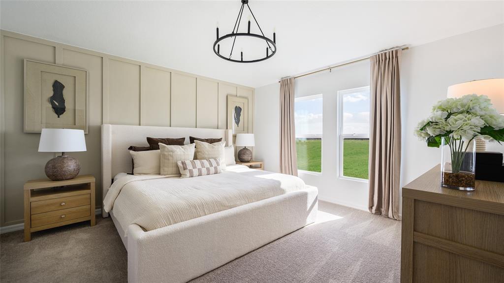 A bedroom features a tufted bed, paneled accent wall, and two windows overlooking a field — 3907 ALTITUDE RUN, DAVENPORT, FL