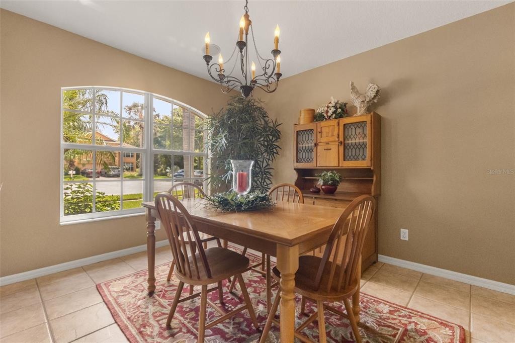 A dining room features a wooden table, chairs, a hutch, and a large arched window — 13813 SIGLER STREET, RIVERVIEW, FL