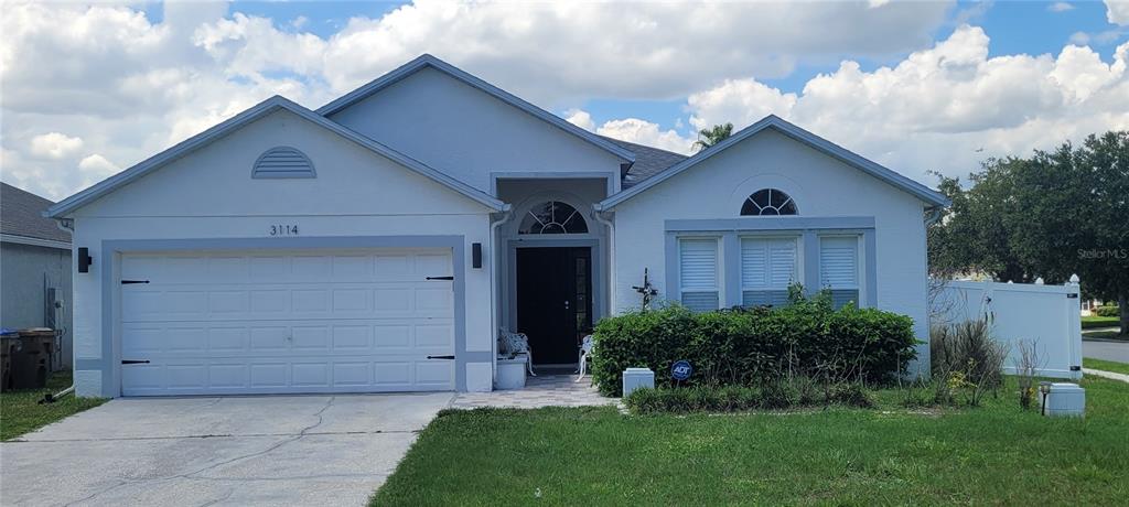 A single-story house with a two-car garage, a front entrance, and a landscaped front yard — 3114 STERN COURT, KISSIMMEE, FL