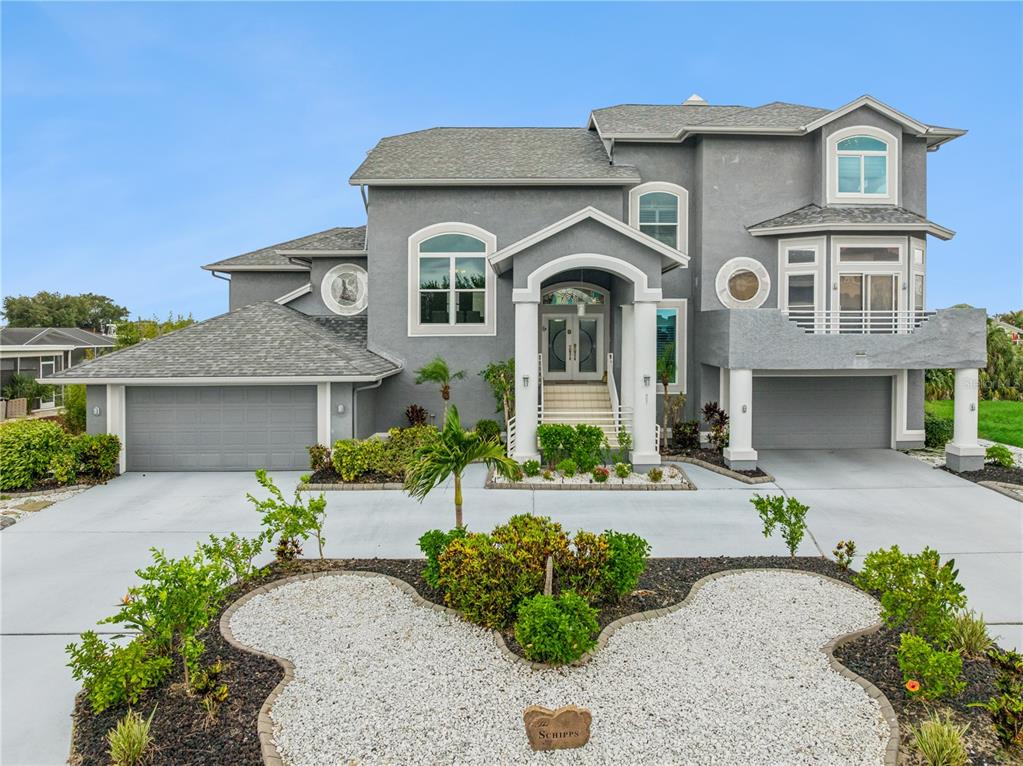 A two-story gray house with a multi-car garage and a landscaped front yard — 807 CHIPAWAY DRIVE, APOLLO BEACH, FL