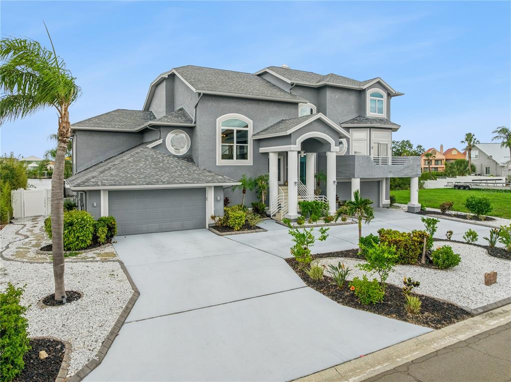 A two-story gray house with a two-car garage, a palm tree, and a concrete driveway — 807 CHIPAWAY DRIVE, APOLLO BEACH, FL
