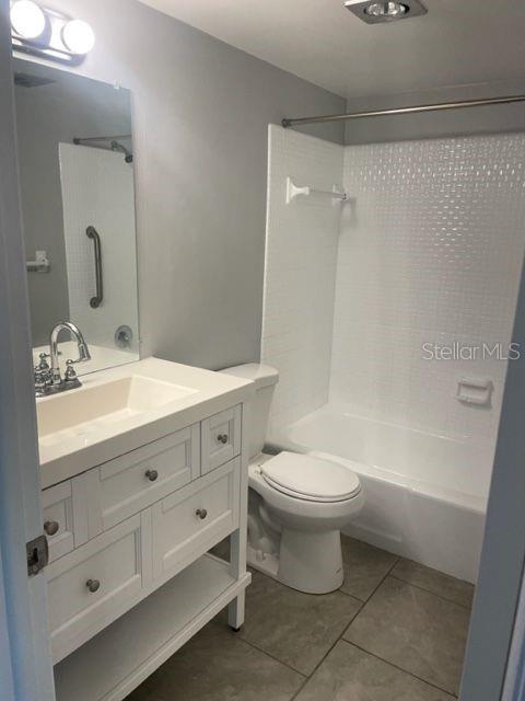 A bathroom features a white vanity, a toilet, and a shower-tub combo with white tiles — 675 INDIAN ROCKS ROAD N UNIT 110D, BELLEAIR BLUFFS, FL