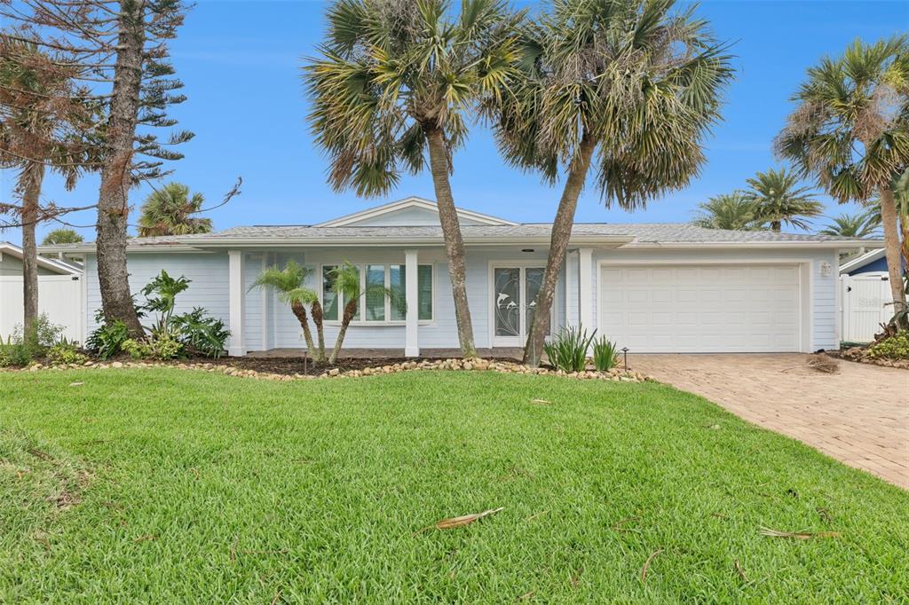 A light blue single-story house with a two-car garage, palm trees, and a paved driveway — 106 ANCHOR DRIVE, PONCE INLET, FL