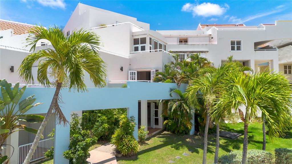 A multi-story white building with a light blue pergola and palm trees in the yard — 125 PALMARINA CLUB UNIT 12, HUMACAO, PR