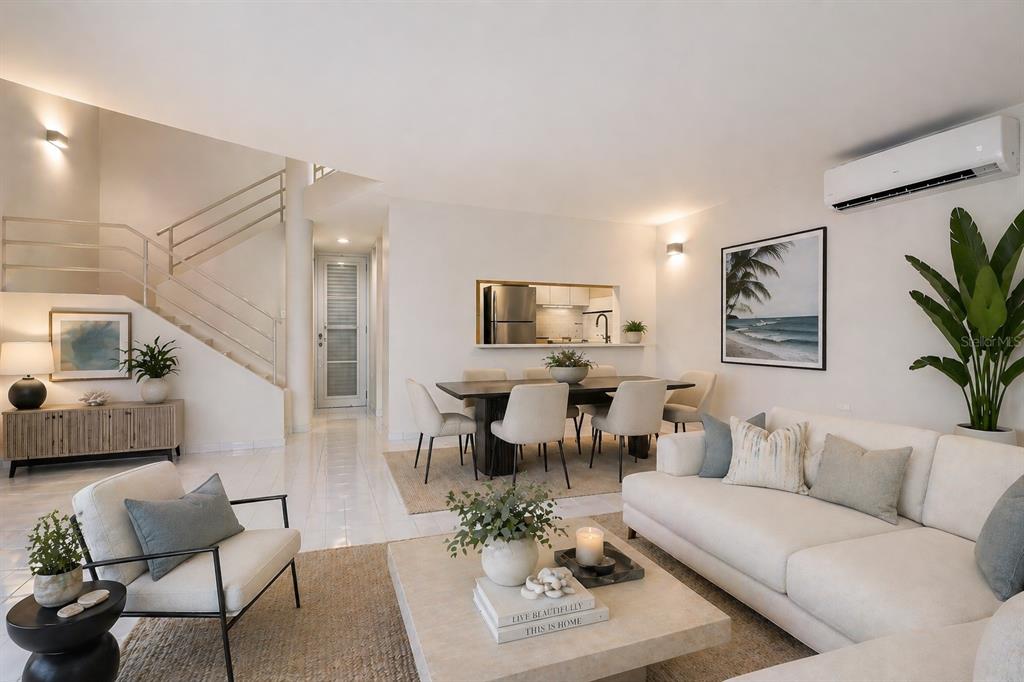 A bright living and dining area features white tile floors, a staircase, and modern furniture — 125 PALMARINA CLUB UNIT 12, HUMACAO, PR