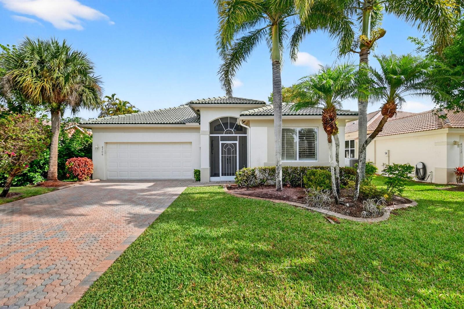 A single-story house with a paved driveway, a two-car garage, and palm trees in front — 8706 Bellido Circle, Boynton Beach FL 33472, BOYNTON BEACH, FL