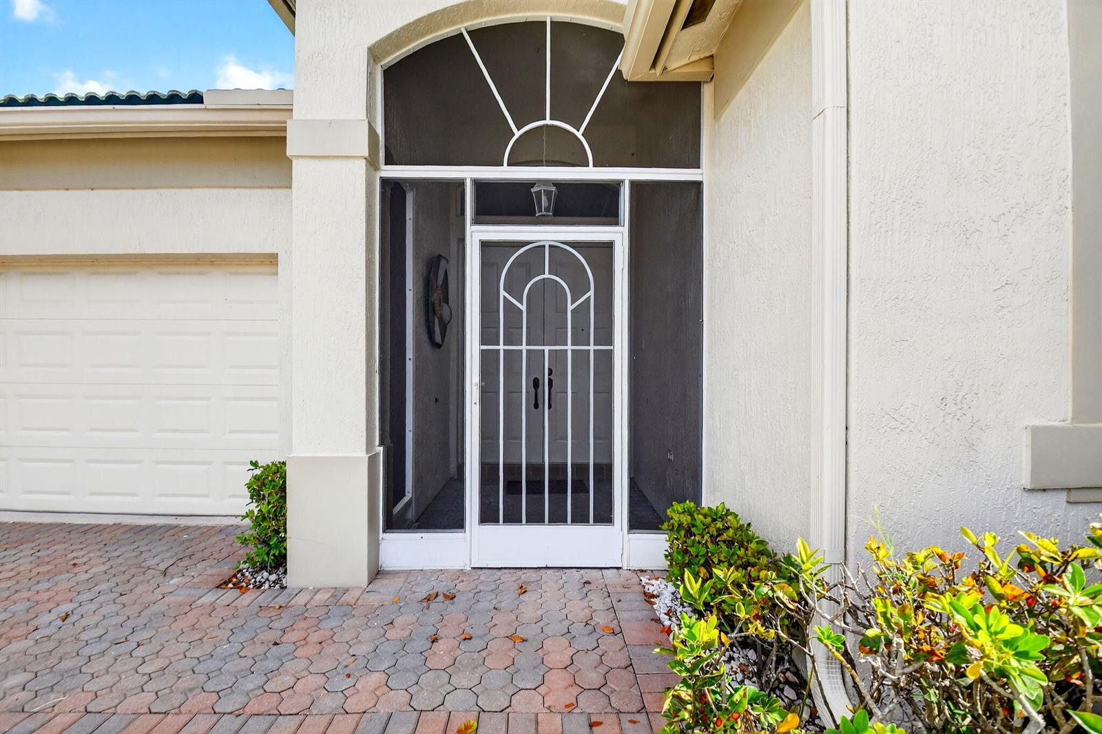 The exterior view shows a white front door with a decorative screen and arched transom — 8706 Bellido Circle, Boynton Beach FL 33472, BOYNTON BEACH, FL