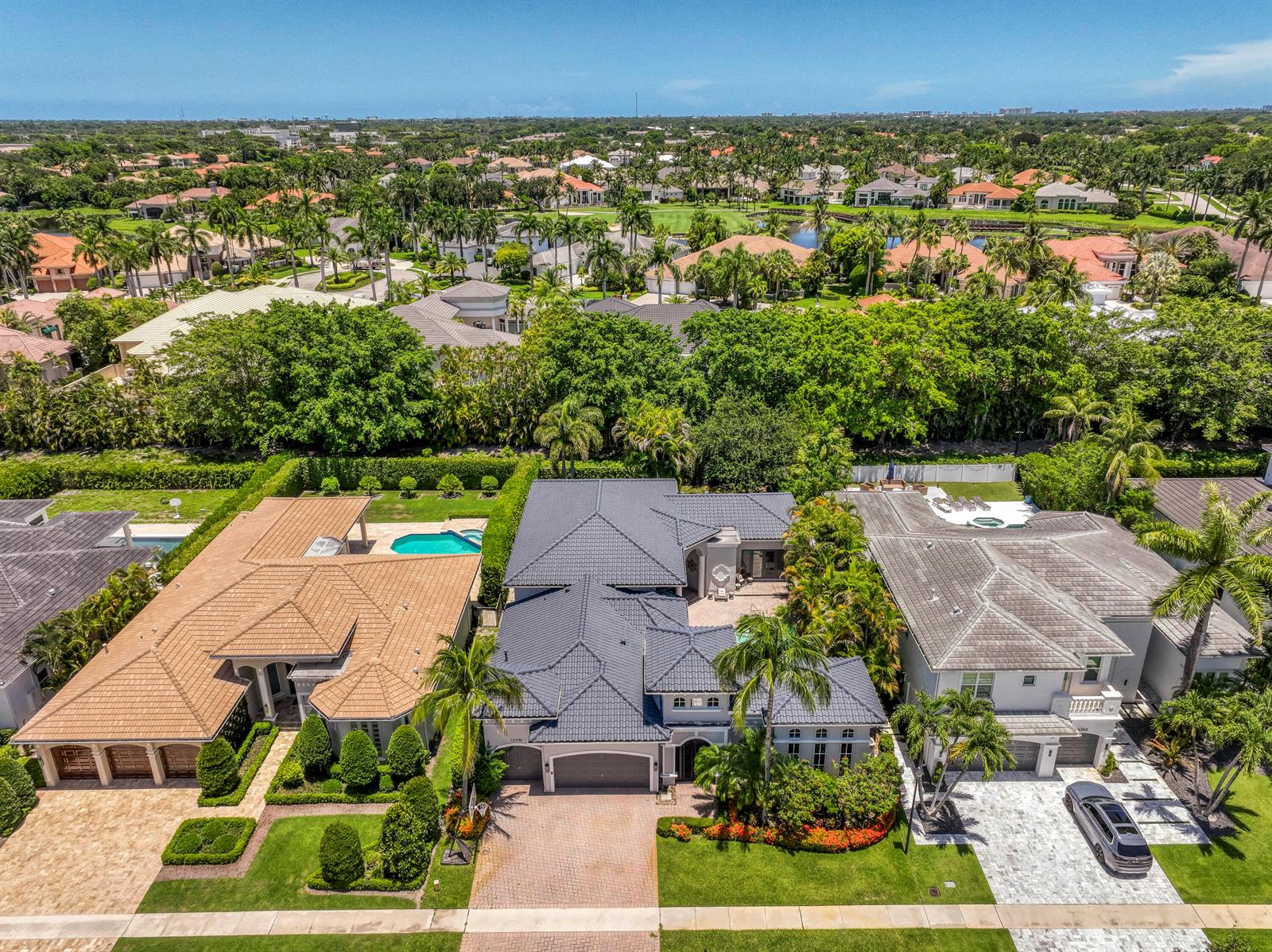 An aerial view shows three suburban houses with tiled roofs, pools, and manicured landscaping — 16340 Via Venetia E, Delray Beach FL 33484, DELRAY BEACH, FL