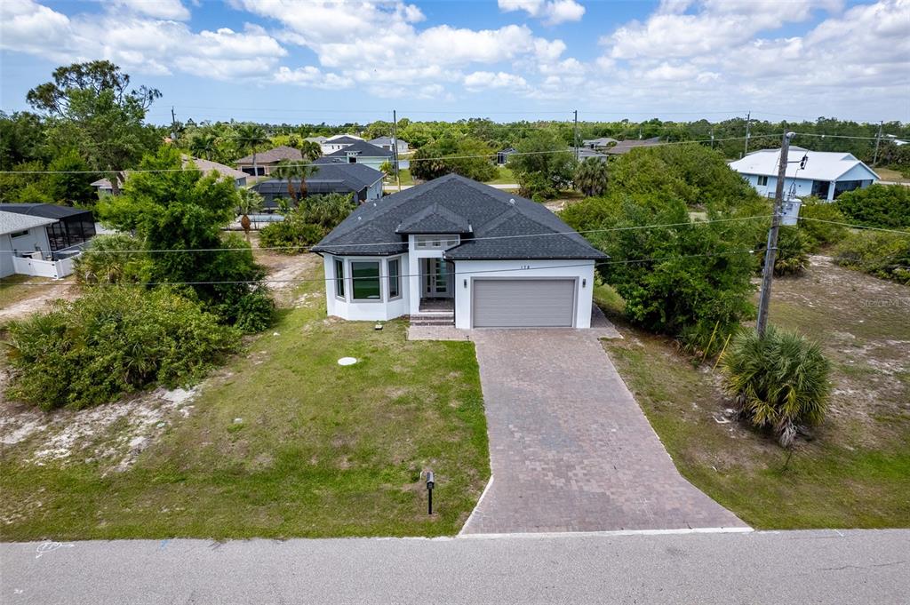An aerial view shows a single-story house with a paved driveway and a shingled roof — 178 LIME TREE PARK, ROTONDA WEST, FL