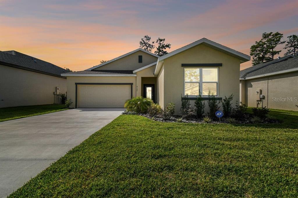 A single-story house with a beige stucco exterior, a two-car garage, and a concrete driveway — 8983 WADE STREET UNIT Plan 1, WEEKI WACHEE, FL