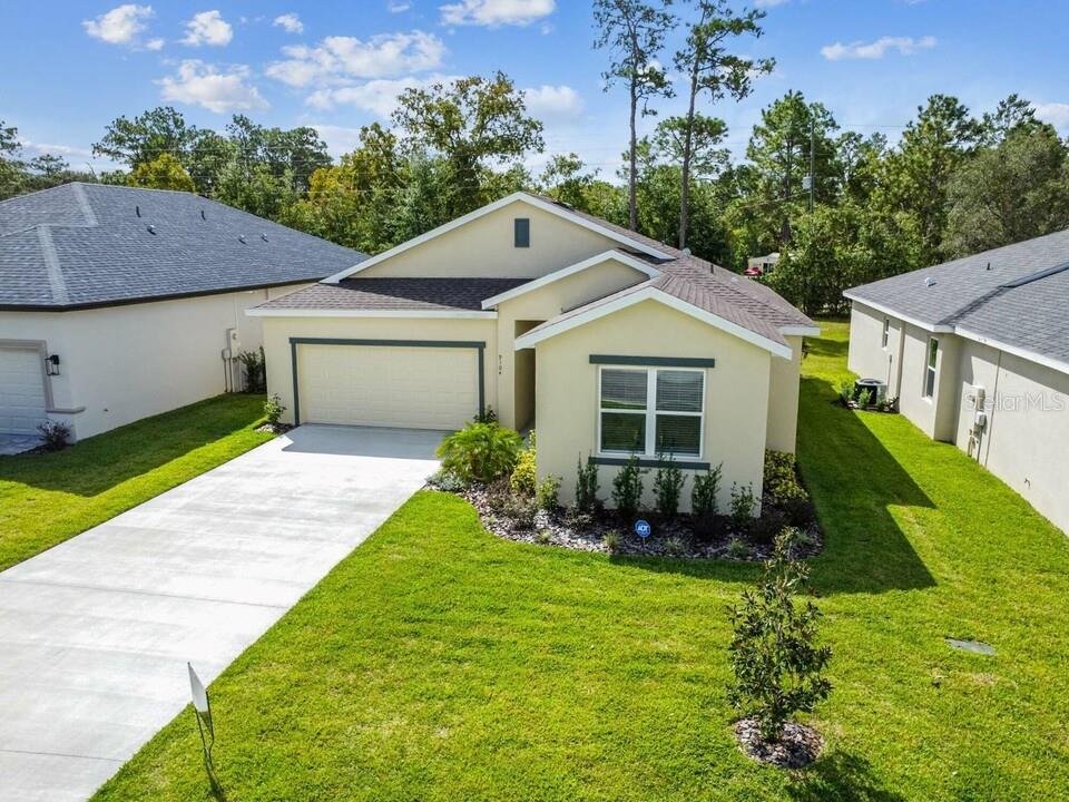 A single-story suburban house with a beige stucco exterior, a two-car garage, and a lawn — 8983 WADE STREET UNIT Plan 1, WEEKI WACHEE, FL