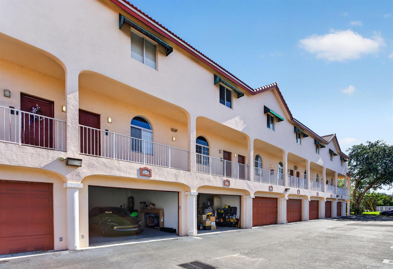 A multi-story residential building features a row of ground-level garages and second-story balconies — 2457 NE 14th Street # 2457, Pompano Beach FL 33062, POMPANO BEACH, FL