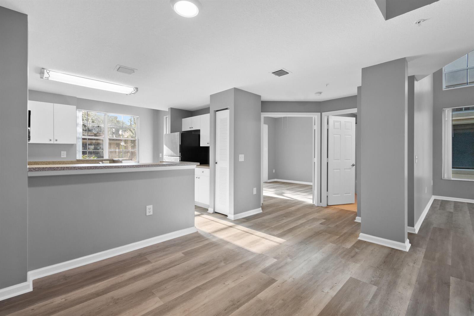 A kitchen with a breakfast bar, grey walls, and light wood-look flooring — 4822 Chancellor Drive # 20, Jupiter FL 33458, JUPITER, FL