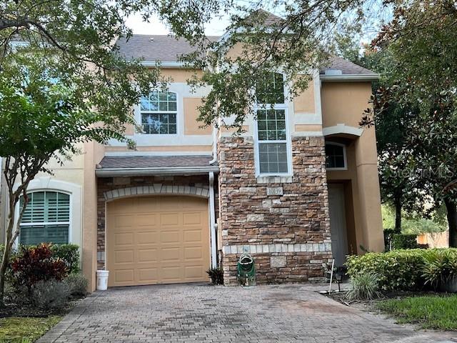 A two-story house with a stone facade, a single-car garage, and a paved driveway — 10139 WILLOW GROVE COURT, ORLANDO, FL