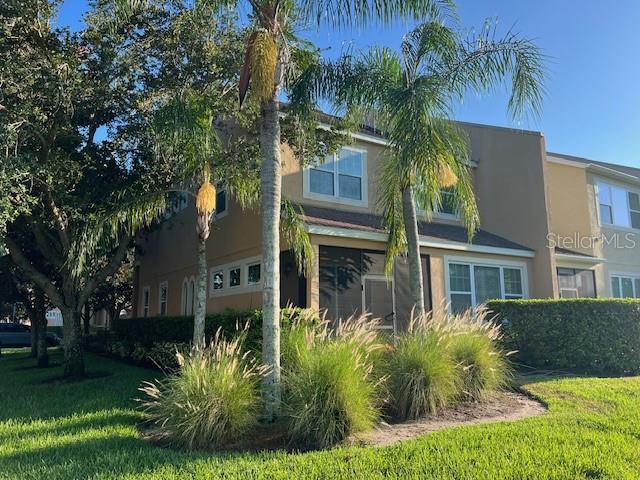 A two-story tan townhouse with a screened-in porch and palm trees in the front yard — 10139 WILLOW GROVE COURT, ORLANDO, FL