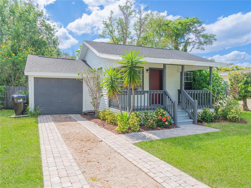 A single-story house with light siding, a gray garage door, and a front porch — 811 OVERSPIN DRIVE, WINTER PARK, FL