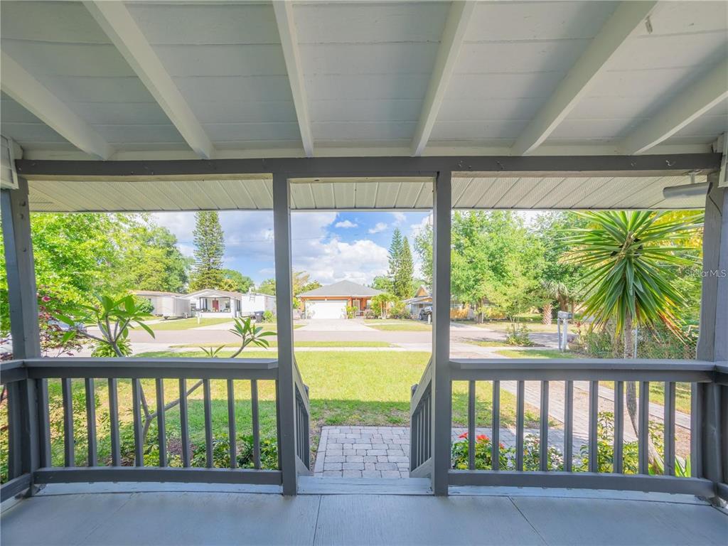 A view from a covered front porch looking out toward a residential street and houses — 811 OVERSPIN DRIVE, WINTER PARK, FL