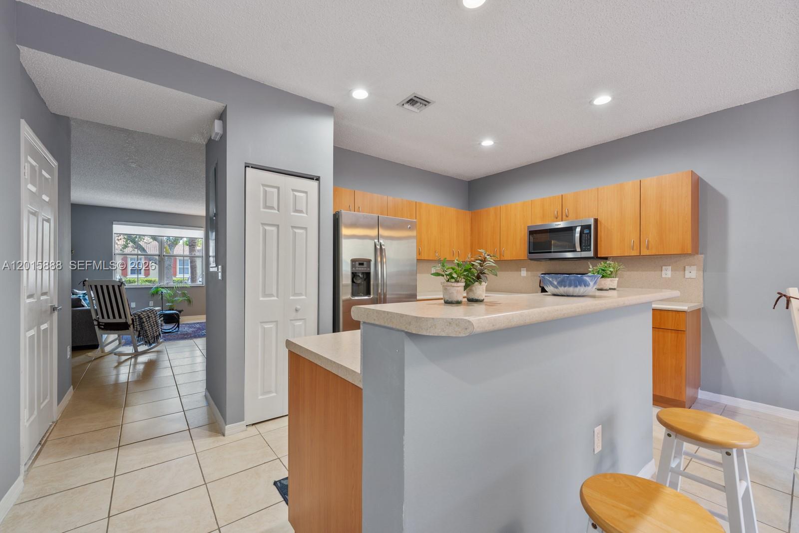 A kitchen with light wood cabinets, stainless steel appliances, and a breakfast bar — 934 NE 42nd Ter, Homestead FL 33033, HOMESTEAD, FL
