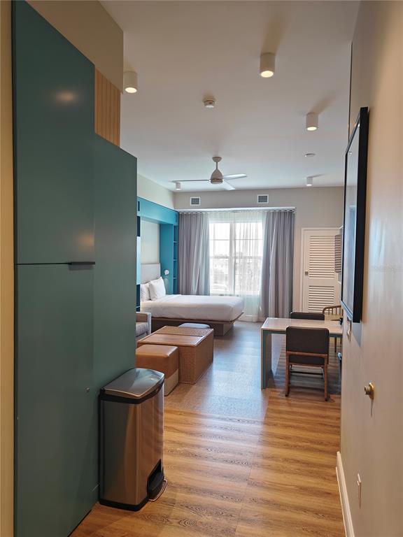 A hotel room features a bed, a dining table, and a teal storage unit — 3151 SUNSET WALK DRIVE UNIT 511, KISSIMMEE, FL