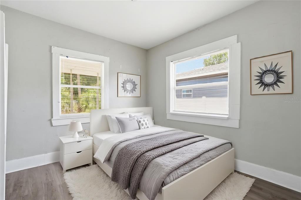 A bedroom features light gray walls, white trim, two windows, and a white bed frame — 1909 19TH STREET S, ST PETERSBURG, FL