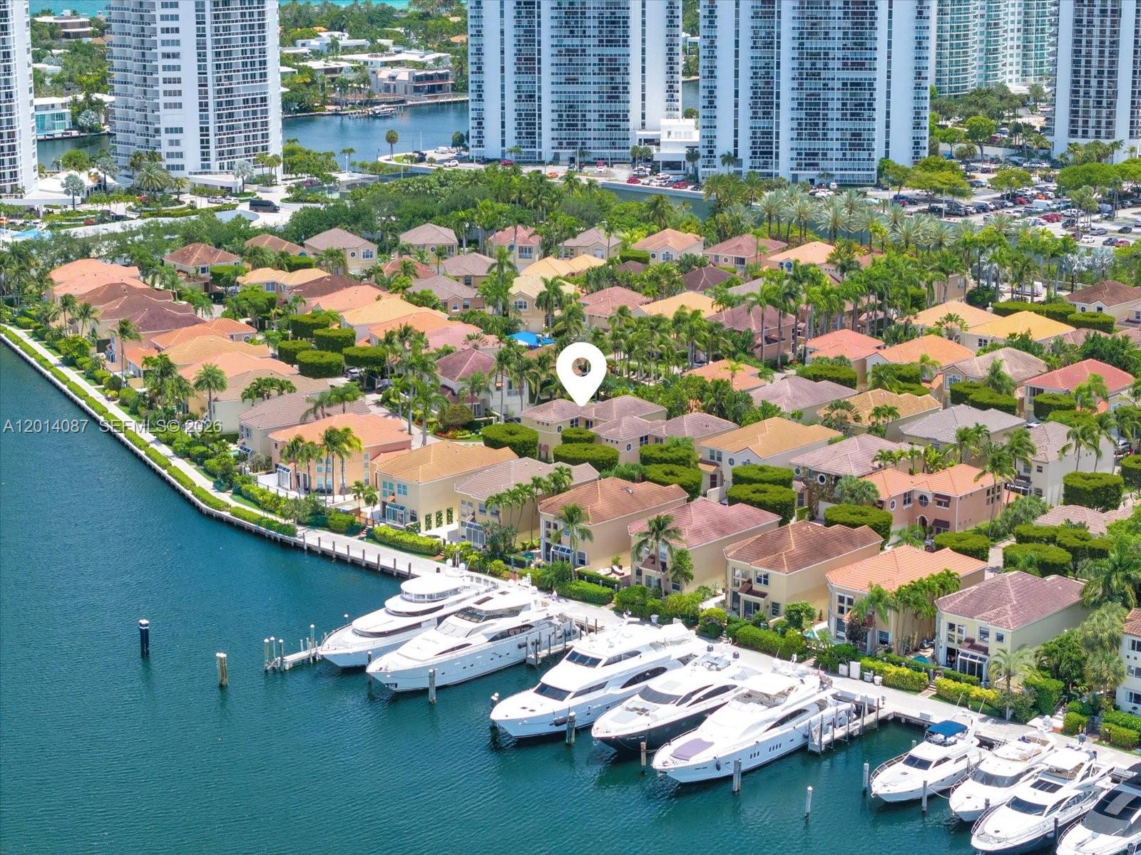 An aerial view of a waterfront residential neighborhood with several yachts docked along the canal — 3728 NE 208th Ter, Aventura FL 33180, AVENTURA, FL