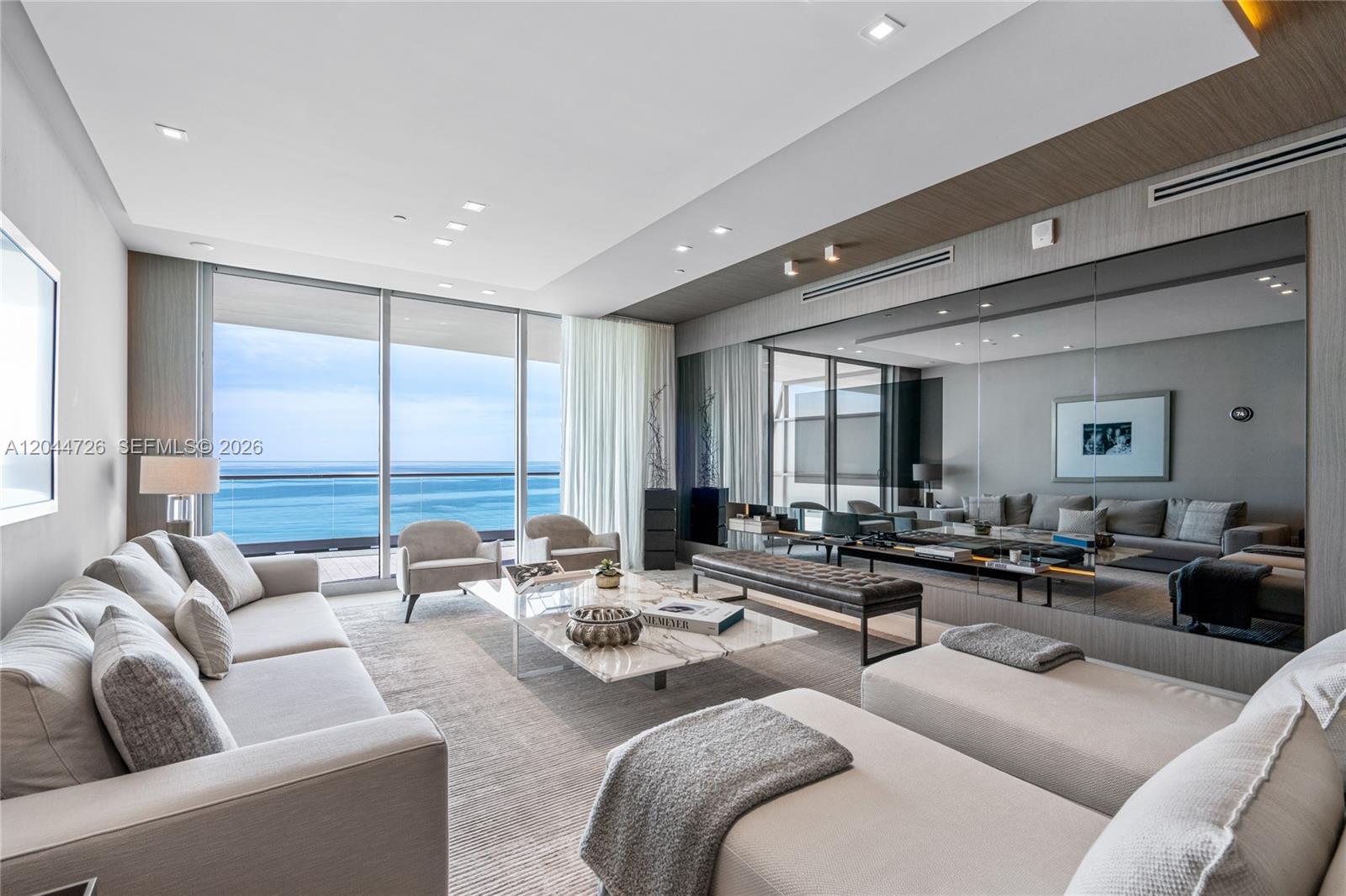 A modern living room features a marble coffee table, plush seating, and floor-to-ceiling ocean views — 9349 Collins Ave # 605, Surfside FL 33154, SURFSIDE, FL
