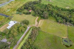 An aerial view shows a rural property with a house, trees, and open fields — 2930 TOHOPEKALIGA DRIVE, ST CLOUD, FL