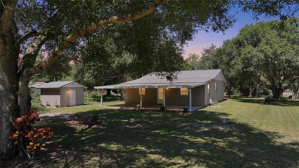 A single-story brick house with a metal roof and a covered front porch — 5549 SW SHORES AVENUE, ARCADIA, FL