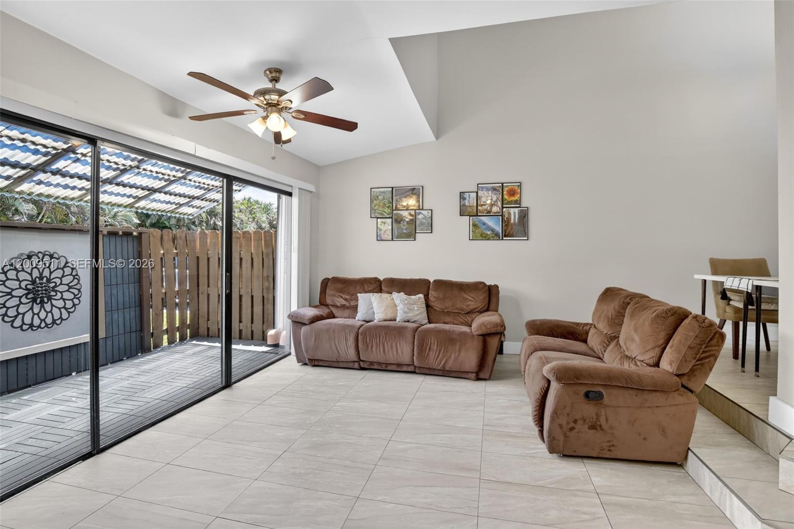 A living room features tile flooring, two brown sofas, a ceiling fan, and sliding glass doors — 4283 S Pine Island Rd, Davie FL 33328, DAVIE, FL