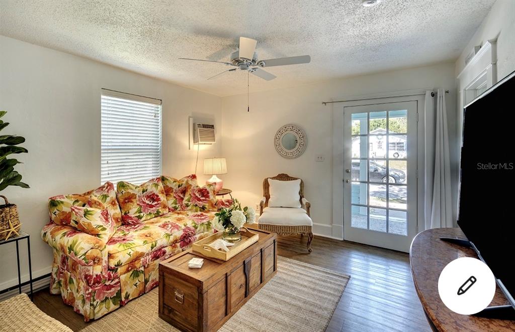 A living room features a floral sofa, wooden trunk coffee table, and a glass-paneled door — 2513 8TH AVENUE W, BRADENTON, FL