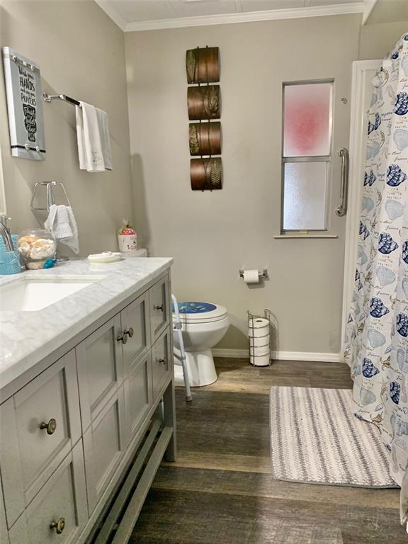 A bathroom features a grey vanity with a marble countertop, toilet, and a shower curtain — 2122 OAK GROVE DRIVE UNIT 79, ZELLWOOD, FL
