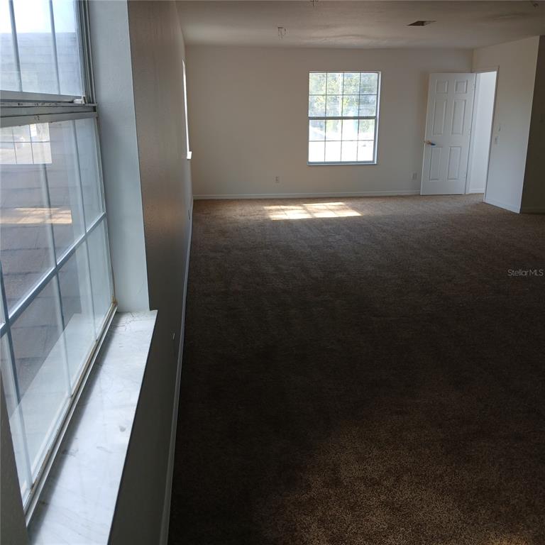 An empty room with brown carpet, white walls, and two windows — 2041 N DONOVAN AVENUE 2nd Fl., CRYSTAL RIVER, FL