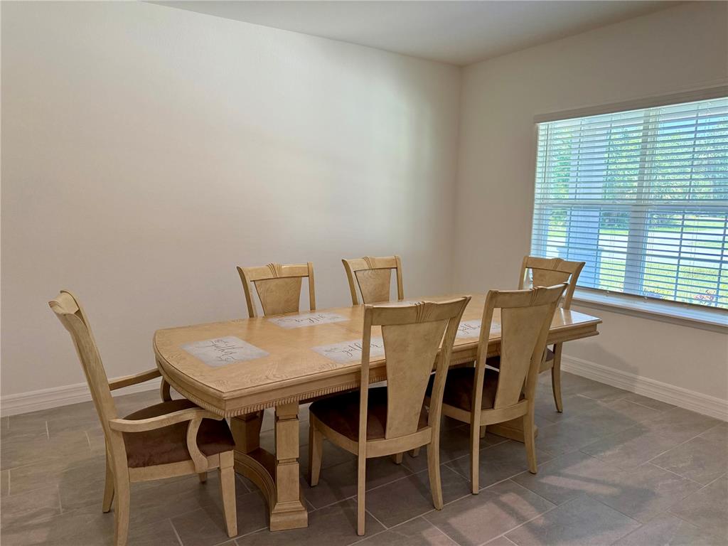 A dining room with a light wood table, six chairs, and tile flooring — 15467 MAYNARD AVENUE, PORT CHARLOTTE, FL