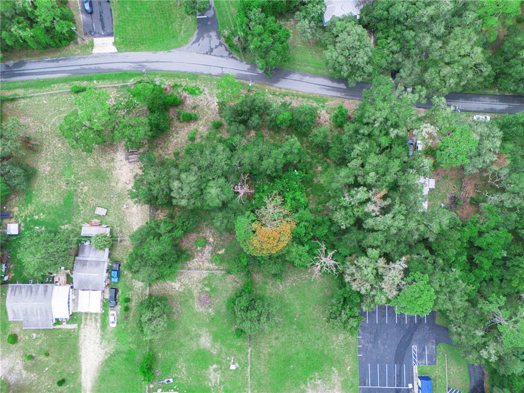An aerial view shows a wooded lot with a house, a parking area, and roads — 7021 N PALMER WAY, HERNANDO, FL