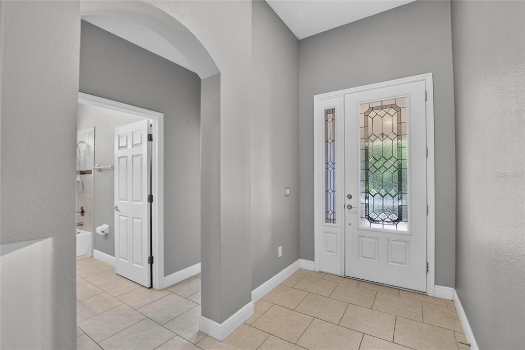 An entryway with light tile flooring, gray walls, and a white front door with glass — 7029 OLD BENTON DRIVE, APOLLO BEACH, FL