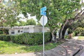 A white single-story house sits behind a large green hedge near a street sign — 190 NE 90th St # 2, El Portal FL 33138, EL PORTAL, FL