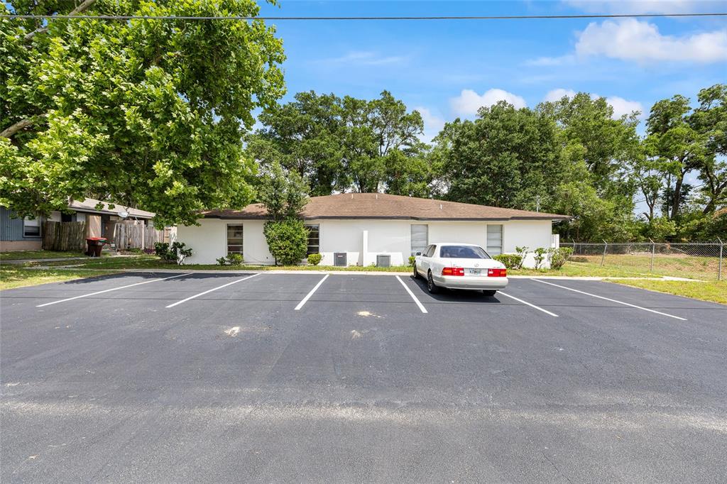 A white, single-story building with a brown roof sits behind a paved parking lot — 3025 SE 55TH AVENUE, OCALA, FL