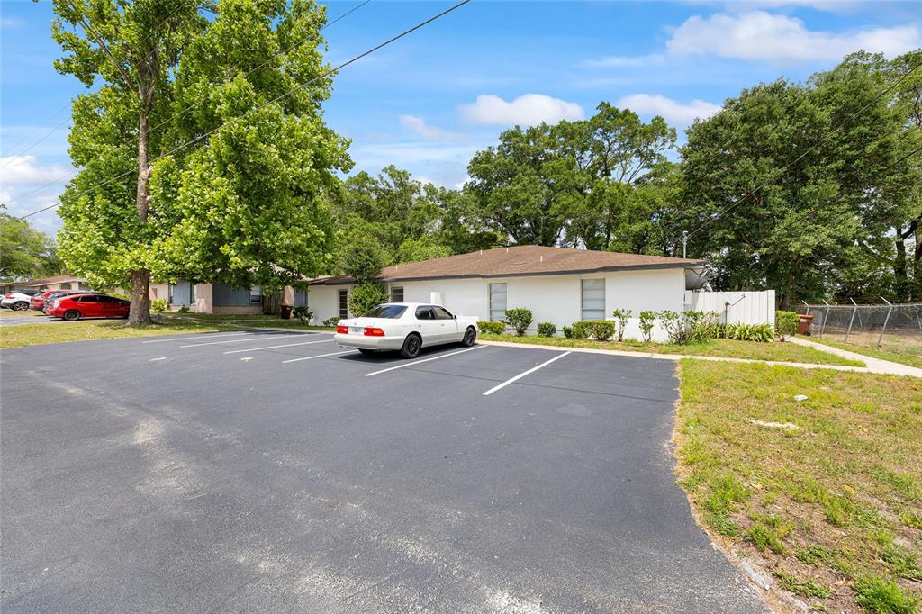 A white single-story building sits behind a paved parking lot with marked spaces — 3025 SE 55TH AVENUE, OCALA, FL