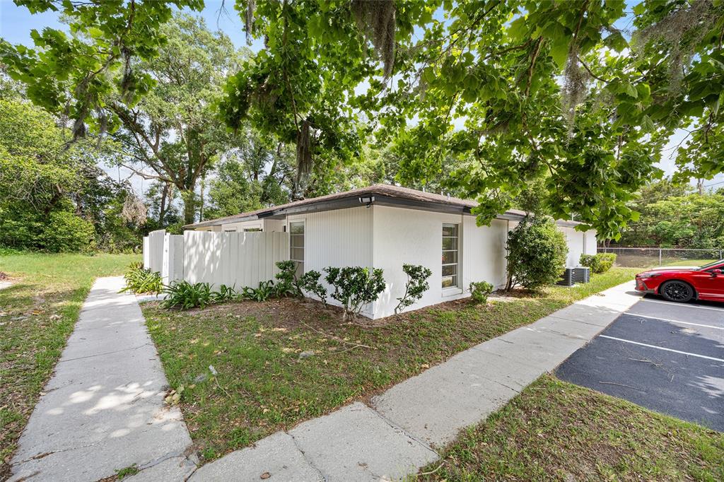 A white single-story building with a fenced side yard and a paved parking area — 3025 SE 55TH AVENUE, OCALA, FL